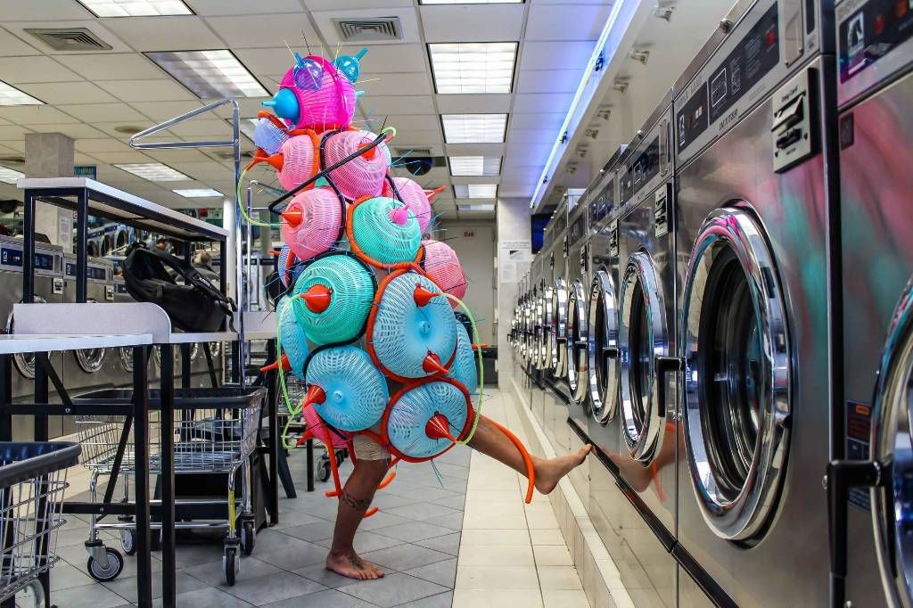 Performer in a sculptural costume by Leeroy New in a laundromat